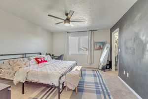 Main bedroom featuring ceiling fan and a textured ceiling