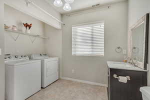 Washroom featuring sink and washer and clothes dryer