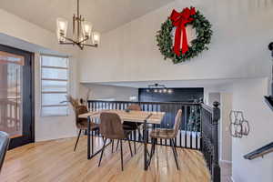 Dining space with hardwood / wood-style floors and a notable chandelier