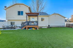 Rear view of property featuring a patio area, a pergola, a yard, and a wooden deck