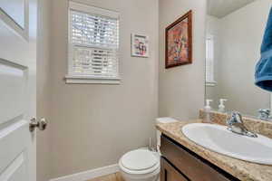 Bathroom featuring tile patterned flooring, vanity, and toilet