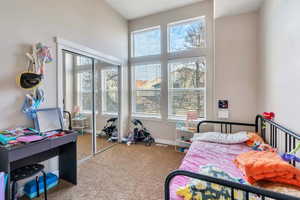 Carpeted bedroom featuring lofted ceiling and a closet