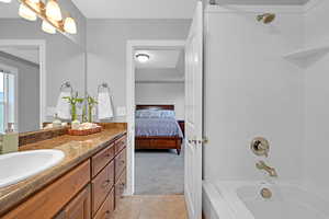 Bathroom with shower / bathtub combination, tile patterned flooring, and vanity