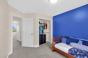 Carpeted bedroom with a closet