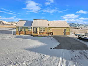 Single story home with a garage, a porch, and a mountain view