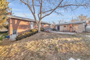 Rear view of house with a patio and a yard