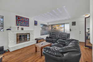 Living room featuring a brick fireplace and hardwood / wood-style flooring