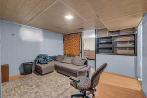 Living room featuring wooden ceiling, wood walls, and hardwood / wood-style floors