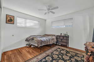 Bedroom with ceiling fan and hardwood / wood-style flooring