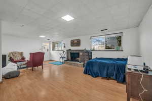 Bedroom featuring light hardwood / wood-style flooring and a brick fireplace