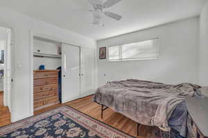 Bedroom with wood-type flooring, a closet, and ceiling fan