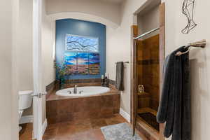 Bathroom featuring toilet, tile patterned floors, and independent shower and bath