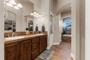 Bathroom featuring vanity, plus walk in shower, and tile patterned floors