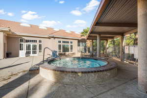 View of swimming pool featuring french doors, an in ground hot tub, and a patio