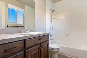 Full bathroom with toilet, vanity, tub / shower combination, and tile patterned floors