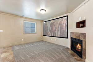 Cinema room with a tiled fireplace, crown molding, and a textured ceiling