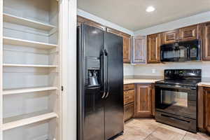 Kitchen featuring black appliances and light tile patterned flooring