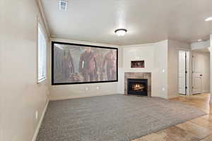 Cinema room featuring carpet and a tiled fireplace