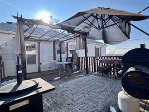 Wooden terrace featuring a grill and a pergola