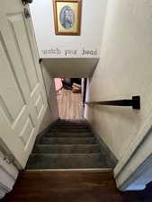 Stairs featuring hardwood / wood-style flooring