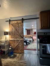 Interior space featuring a textured ceiling, hardwood / wood-style floors, and a barn door