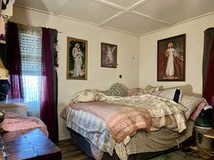 Bedroom featuring dark hardwood / wood-style flooring and coffered ceiling