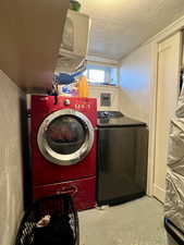 Washroom featuring a textured ceiling and separate washer and dryer