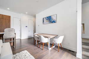 Dining area with dark wood-type flooring