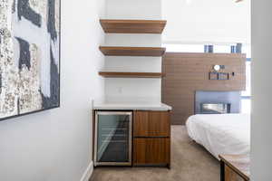 Carpeted bedroom featuring wine cooler