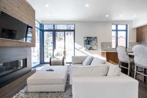 Living room with expansive windows and dark hardwood / wood-style flooring