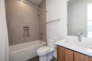 Full bathroom with vanity, shower / bath combo with shower curtain, and toilet