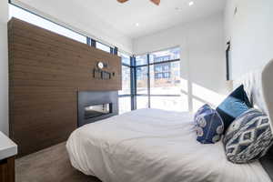 Bedroom with ceiling fan and wood walls