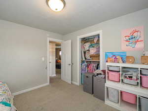 Playroom with a textured ceiling and light carpet