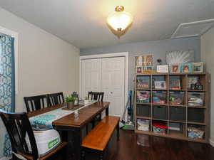 Dining space featuring a textured ceiling and dark wood-type flooring