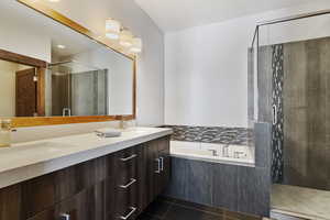 Bathroom featuring plus walk in shower, tile patterned floors, and vanity