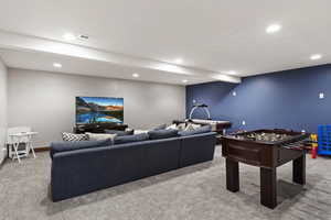 Rec room featuring beam ceiling and light colored carpet