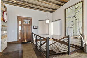 Entrance foyer featuring beam ceiling and dark wood-type flooring