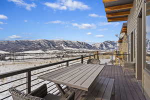 Snow covered back of property with a mountain view