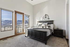 Bedroom featuring carpet floors, access to exterior, and a mountain view