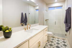 The bathroom adjacent to bedroom three includes quartz counters, elegant fixtures, euro-style glass, and a grand feel with it's floor to ceiling tiled shower.