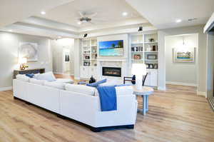 Great Room with coffered ceiling, fan, built-in shelving, and gas fireplace.