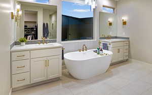 Owner's bath with garden tub, dual vanities, elegant lighting and brush 'gold' Delta Trinsic fixtures.