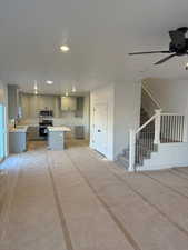 Kitchen featuring a kitchen island, stainless steel appliances, sink, ceiling fan, and gray cabinetry