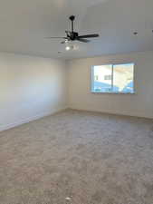 Spare room with ceiling fan and carpet