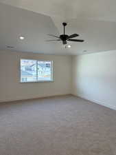 Carpeted spare room featuring ceiling fan