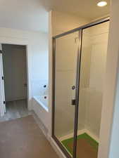 Bathroom featuring wood-type flooring and plus walk in shower