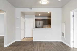 Unfurnished living room featuring sink and dark wood-type flooring