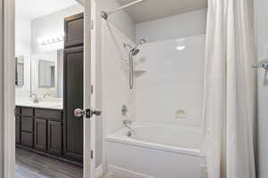 Bathroom with hardwood / wood-style flooring, vanity, and shower / bath combo with shower curtain