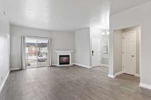 Unfurnished living room with a notable chandelier and light hardwood / wood-style floors