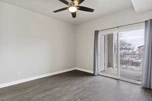 Empty room with dark hardwood / wood-style floors and ceiling fan